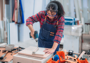 Experienced carpenter expertly drills precise holes, crafting furniture with practiced skill