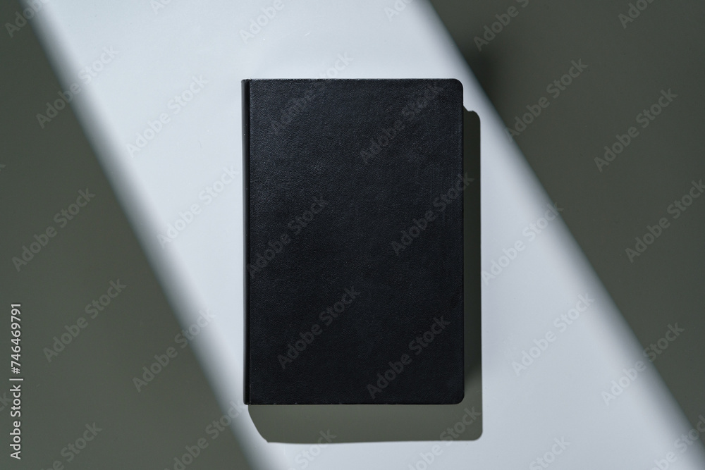 Poster Black notepad with hard cover on gray background