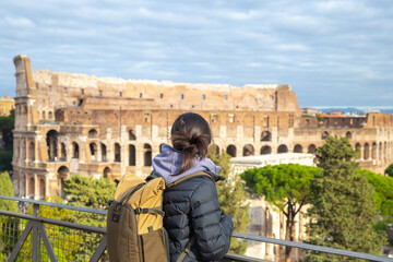 an asian girl looking at the colosseum from distance in Rome, Italy, tourist, travel