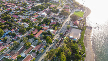 Aerial drone view of the capital city of Dili, Timor-Leste in Southeast Asia with waterfront road, white sandy beach and ocean