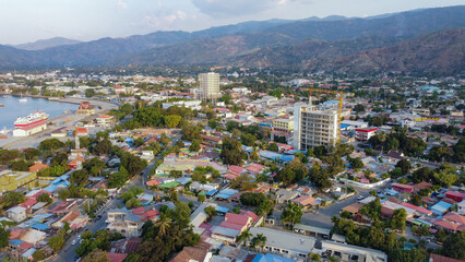 Scenic aerial landscape view of the capital city of Dili, Timor-Leste in Southeast Asia with inner city houses, buildings, hills and a glimpse of ocean