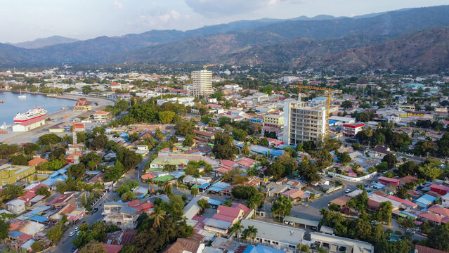 Fototapeta Scenic aerial landscape view of the capital city of Dili, Timor-Leste in Southeast Asia with inner city houses, buildings, hills and a glimpse of ocean