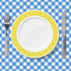 Yellow dish with pattern of chaotic white polka dot with knife and fork placed on blue classic table cloth