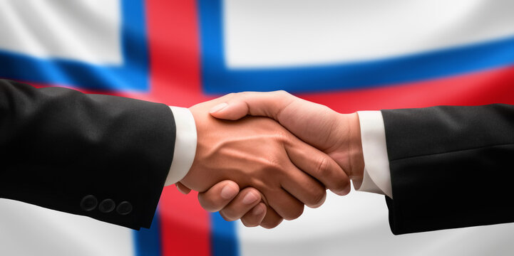 Businessman and diplomat in suits clasp hands for handshake over Faroes flag, agree on united success in trade, diplomacy, cooperation, negotiation, support, teamwork in commerce, gesture of greeting