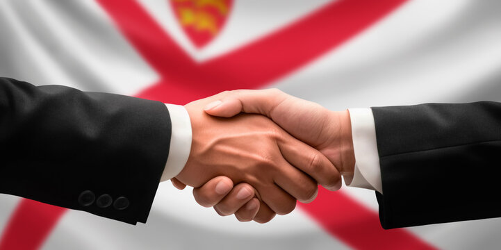 Businessman and diplomat in suits clasp hands for handshake over Jersey flag, agree on united success in trade, diplomacy, cooperation, negotiation, support, teamwork in commerce, gesture of greeting