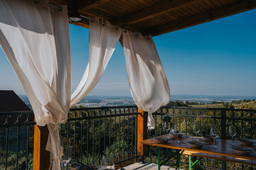 A serene and picturesque view from a rustic wooden balcony, beautifully set for an intimate...