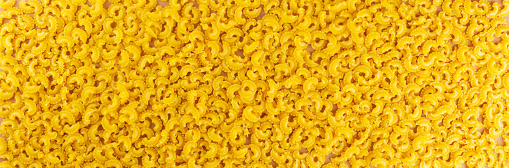 Banner Creste Di Gallo dry, raw pasta. Rooster scallop. Top view.