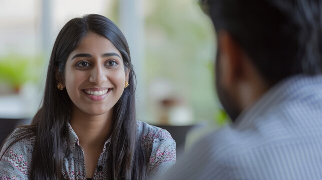 A smiling woman having a conversation with a man