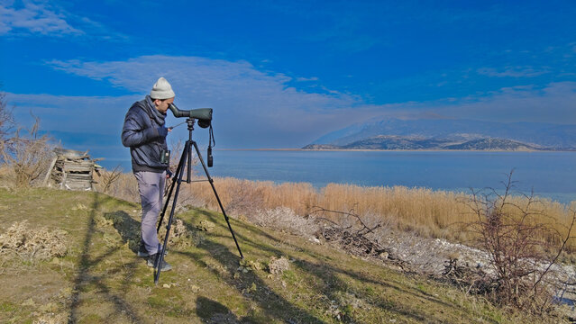 A man birdwatching with a telescope in the lake. Lake Egirdir in Turkey.
