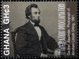 Photograph of Abraham Lincoln sitting on postage stamp