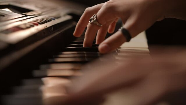 Close-up. Female hands play the synthesizer