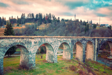 View of the old aqueduct and the city on the hills in autumn. Vorokhta, Ukraine, Europe