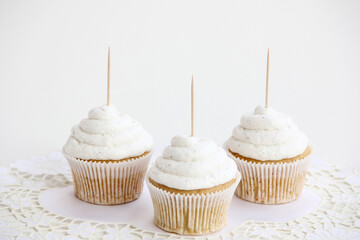 Three Vanilla Cupcakes Topper Mockup. 3 cupcake with wooden toothpick in white background Copy space for your design here. Blank mockup for advertising and promotions