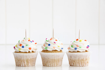 Colorful sprinkles Three Cupcakes Topper Mockup. 3 cupcake styled against a white background with...