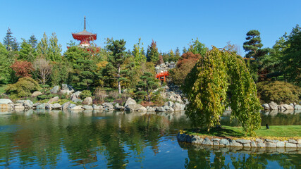 Beautiful view of Kagamiike Mirror Pond against Tahoto Pagoda in Japanese garden. Public landscape park of Krasnodar or Galitsky park, Russia.