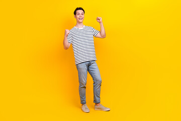 Full size photo of overjoyed student dressed striped t-shirt jeans trousers win betting scream yeah isolated on yellow color background