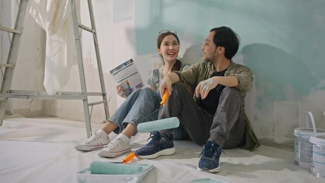 New home,Repair,happy,New life,insurance,carefree relationship,love lifestyle,new apartment,renovation and decorating concept.Young asian couple choosing blue color.happy smiling asian couple in home