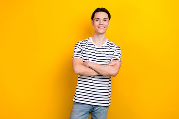 Photo of cheerful guy with stylish hairdo dressed striped t-shirt standing arms crossed isolated on...