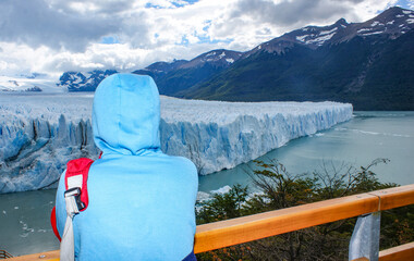 Young Woman in Vibrant Attire Admiring the Majesty of the Glacier