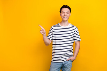 Photo of positive guy with stylish hairdo dressed striped t-shirt indicating at promo empty space...
