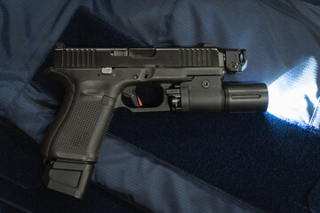 Tactical g19 pistol with a flashlight on a police vest.