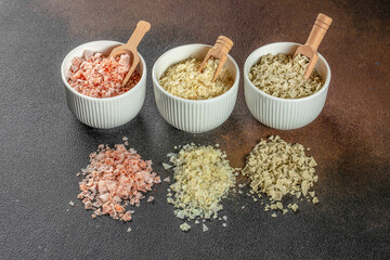 Three types of salt in bowls. Basil, paprika and lemon, cooking background. menu