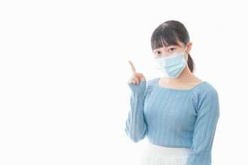 ポイントを指差すマスクを付けた若い女性