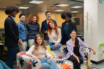 A group of happy colleagues in smart casual wear, posing in a relaxed and friendly office atmosphere. 