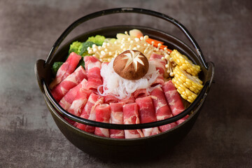 Fat beef rolls and vegetable ingredients placed in black hot pot