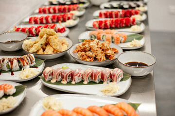 table full of different sushi rolls on plates with decor