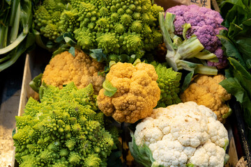 colored cauliflowers and broccoli on sale at the market