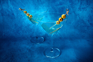 Martini. Two glasses of dirty martini cocktails with vermouth and olives, aperitif, on a blue...