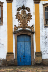 Image shows details of the entrance door to the church of Nossa Senhora das Mercês in Ouro Preto