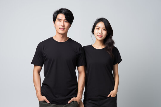 Young asian couple in black t-shirt on gray wall background for clothing mockup