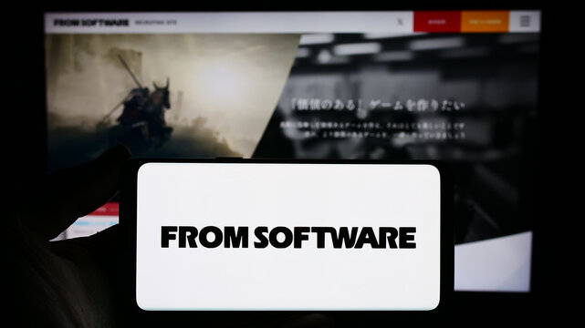 Stuttgart, Germany - 02-19-2024: Person holding smartphone with logo of Japanese video games company FromSoftware Inc. in front of website. Focus on phone display.
