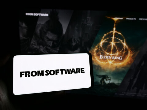 Stuttgart, Germany - 02-19-2024: Person holding mobile phone with logo of Japanese video games company FromSoftware Inc. in front of business web page. Focus on phone display.