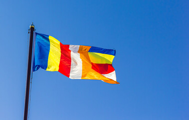 Buddhist flag against a blue sky in Dabei Monastery in Tianjin, China