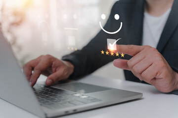 Business people touch virtual screens on the happy Smile face icon to give satisfaction in service. rating very impressed. Customer service and Satisfaction concept.