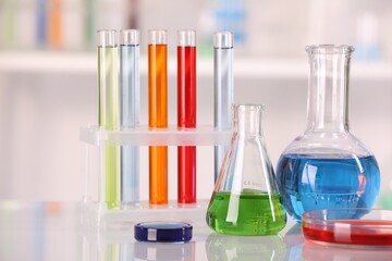 Laboratory analysis. Different glassware with liquids on white table against blurred background