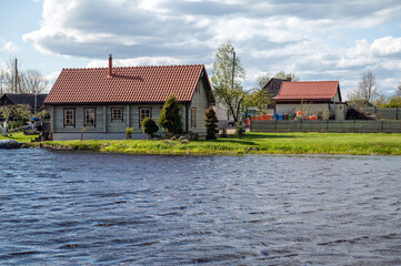 Old wooden houses on the bank of the river in the village.