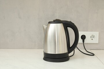 Modern electric kettle on counter in kitchen. Space for text