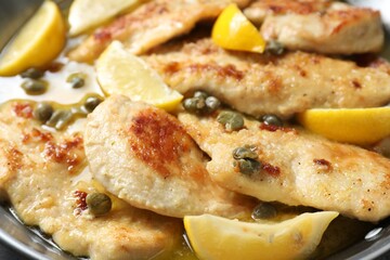 Delicious chicken piccata with lemons in pot, closeup