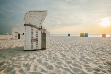 Beach cabins on white sand. Beach wicker baskets on the sea coast of the northern sea. Vacation on...