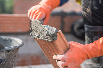 Hand plaster putting cement brown brick masonry structure building 