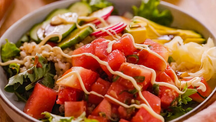 Fresh salad with vegetables, avocado, rise in bowl. Homemade delicious lunch buddha bowl salad with tomato for restaurant, menu, advert or package, close up selective focus