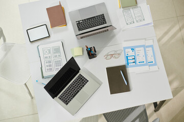 Laptops and documents on office desk of ui designers