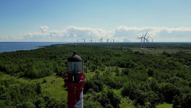 Lighthouse of Pakri with wind generators on background and Baltic sea in the background. Sea Coast With A Steep Bank in Estonia. Wild Coast Of Baltic Sea, Steep Bank and lighthouse. 