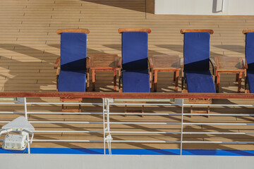 Deck chairs or sun loungers with table on balcony or terrace or patio of luxury modern cruise ship...