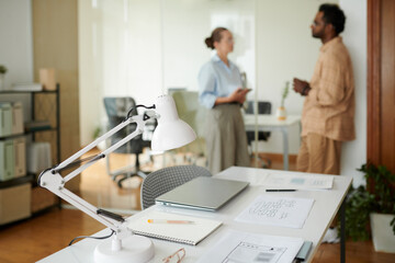 Office desk of ui designer with laptop, notebook and website wireframes