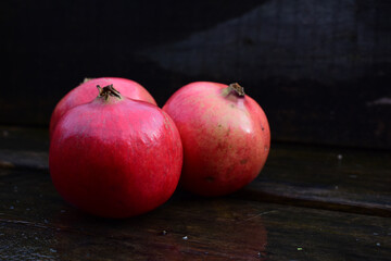 Granatapfel, drei Granatäpfel edel vor dunklem Hintergrund, rot, reif und frisch